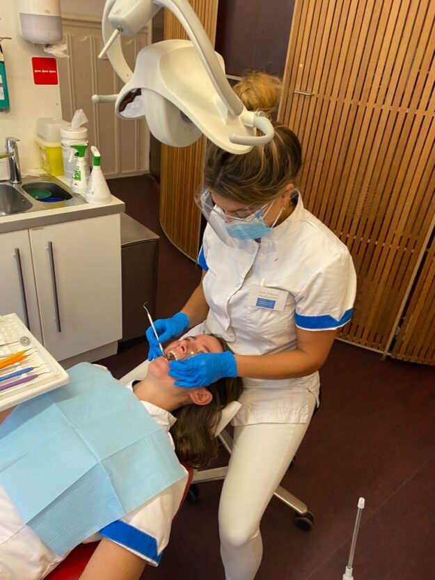 Mondhygiëniste Emilie helpt een patiënt bij het behandelen van Tandsteen