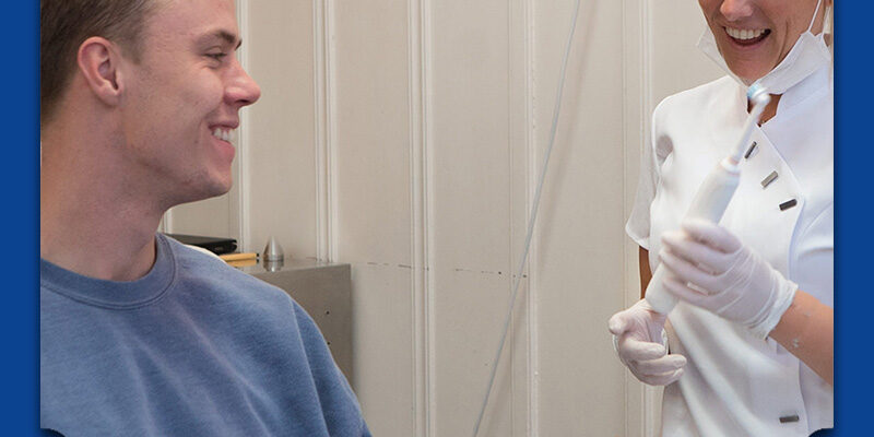 Tandarts geeft uitleg over mondhygiëne aan patient
