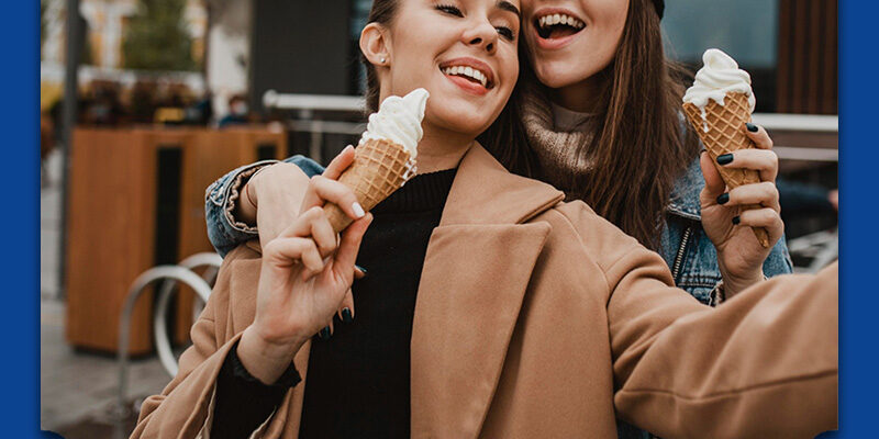 Meisjes eten een ijsje en maken een selfie. Ze hebben geen last van gevoelige tanden.